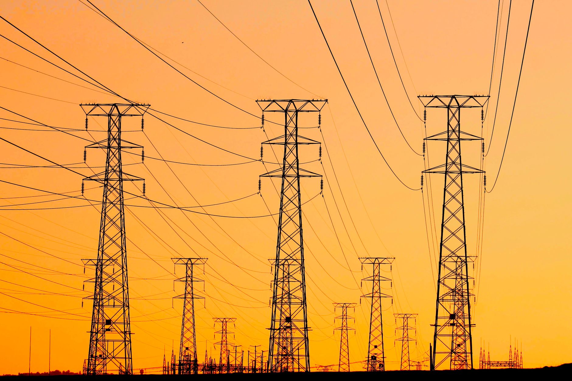 high voltage transmission towers at sunset